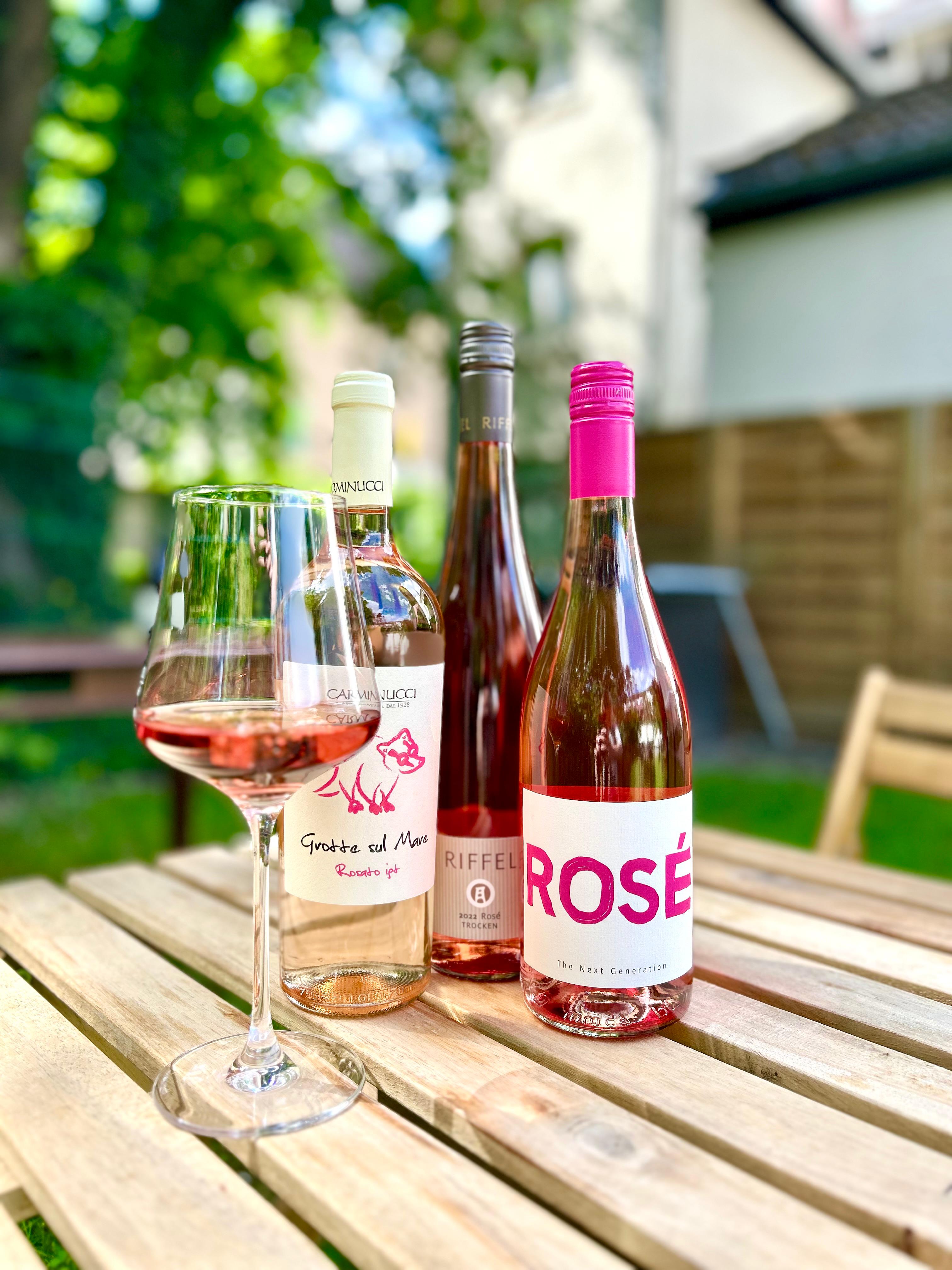 Roséflaschen von Riffel, Carminucci und Next Generation, in Weinglas beim Weinhandel WineAmigos